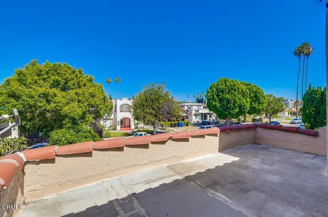 a view of a street with a bench and some trees