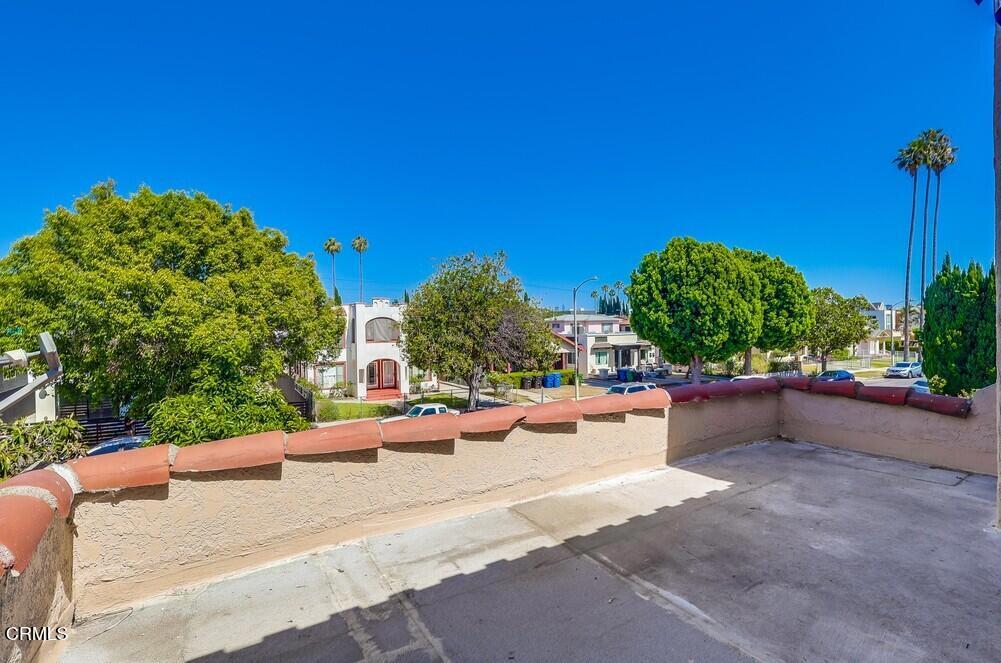 833-835 North Ridgewood Place Los Angeles, CA 90038 - Photo 20 of 28 a view of a street with a bench and some trees