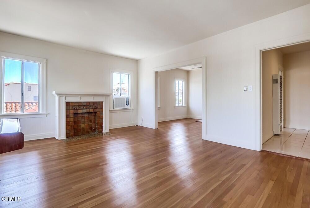 833-835 North Ridgewood Place Los Angeles, CA 90038 - Photo 6 of 28 an empty room with wooden floor fireplace and windows