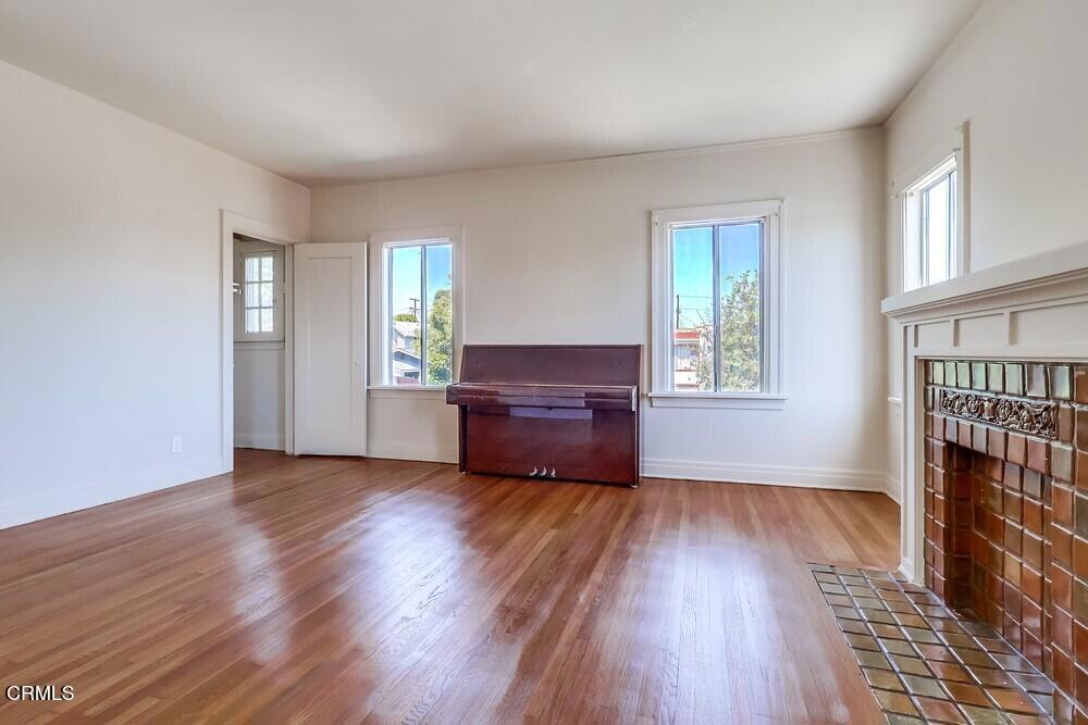 833-835 North Ridgewood Place Los Angeles, CA 90038 - Photo 7 of 28 an empty room with wooden floor and windows