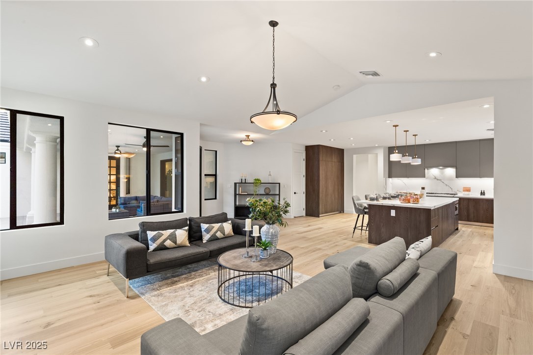 2316 Prometheus Court Henderson, NV 89074 - Photo 24 of 92 Living room with light wood-style floors, visible vents, vaulted ceiling, recessed lighting, and baseboards