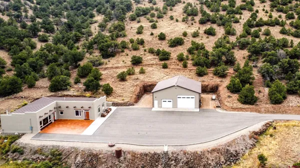 an aerial view of a house with a yard and trees