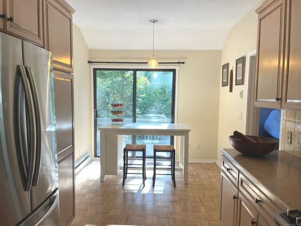 a kitchen with stainless steel appliances granite countertop a refrigerator a stove and a wooden floors