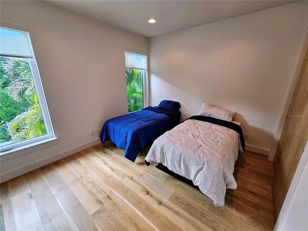 a living room with stainless steel appliances furniture a fireplace and a large window