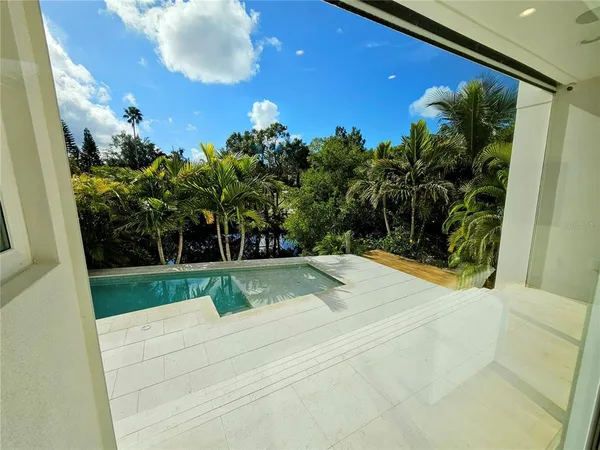 a view of a utility room with stainless steel appliances wooden floor and chair