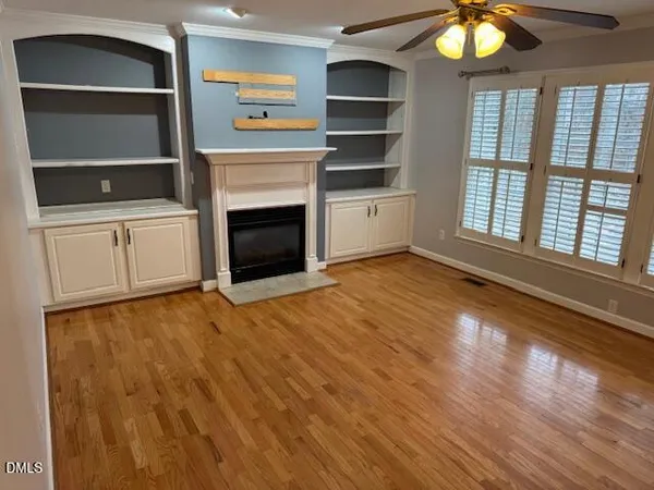 a view of an empty room with a fireplace and a window