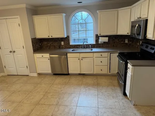 a kitchen with stainless steel appliances granite countertop a stove a sink and a white cabinets