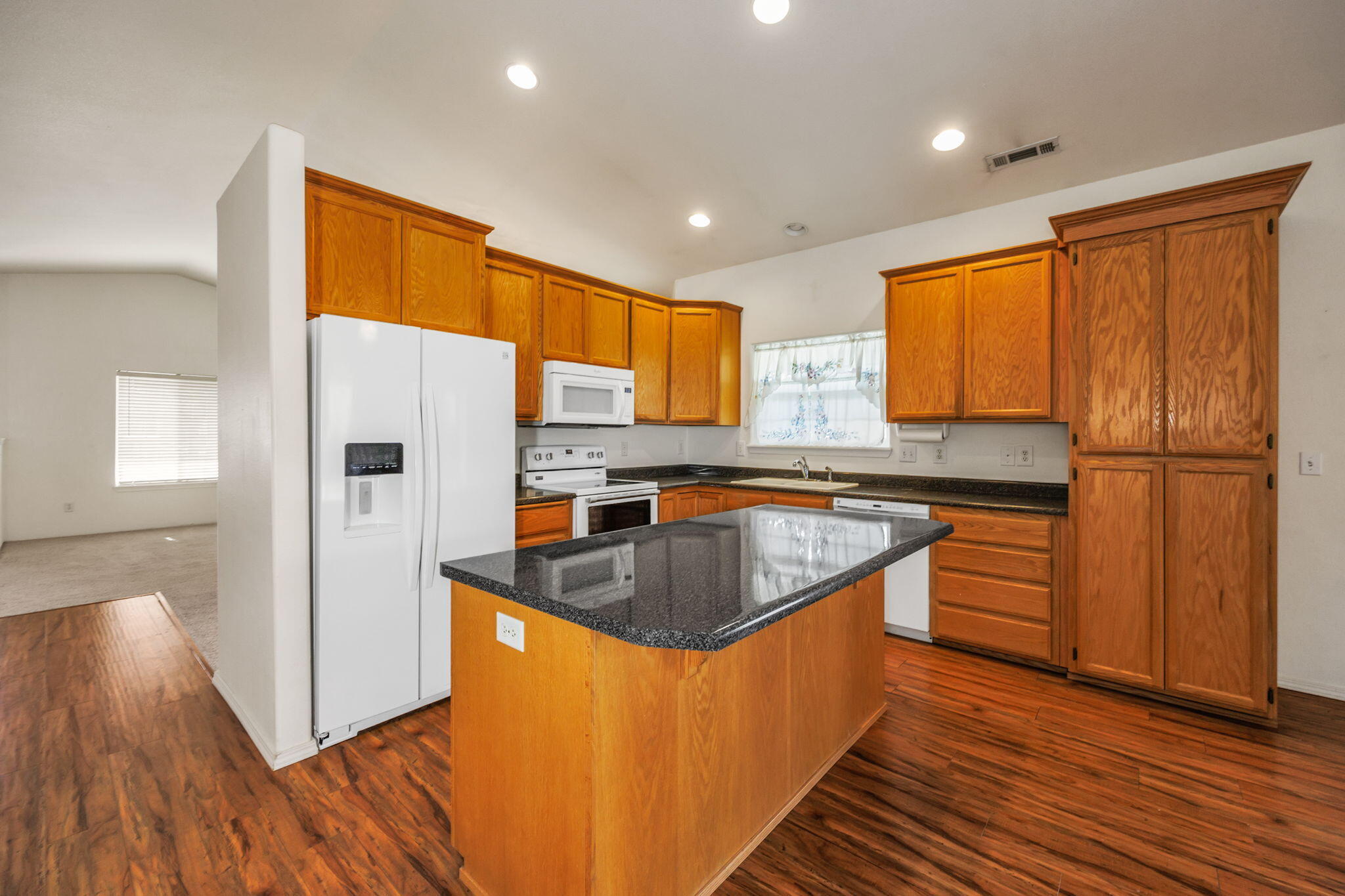 9 Chantrell Court Eagle Point, OR 97524 - Photo 25 of 37 a kitchen with stainless steel appliances granite countertop a refrigerator a sink dishwasher a stove with wooden cabinets and wooden floor