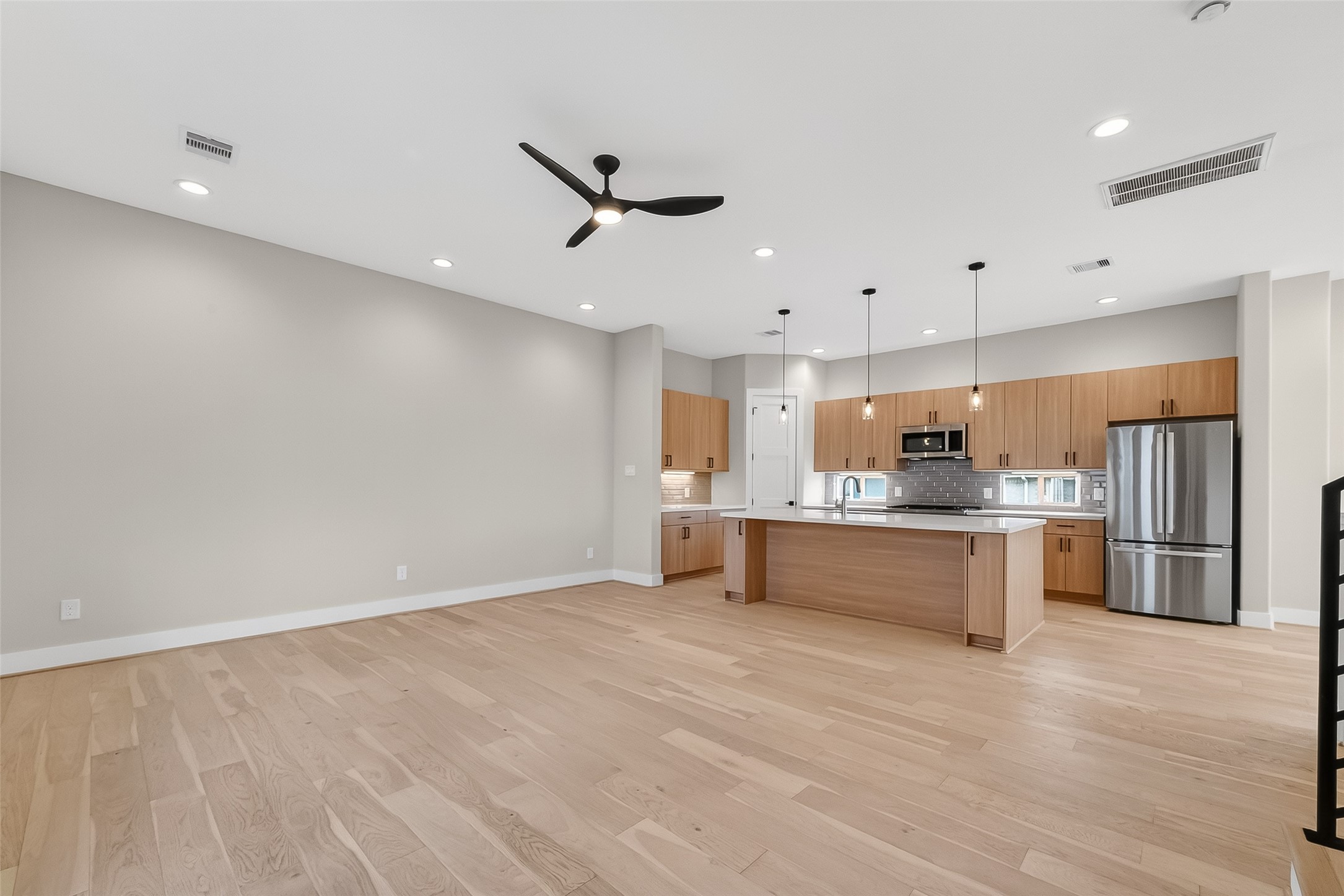 2511 North MacGregor Way Houston, TX 77004 - Photo 15 of 42 a large white kitchen with a refrigerator a stove top oven a sink cabinets and wooden floor