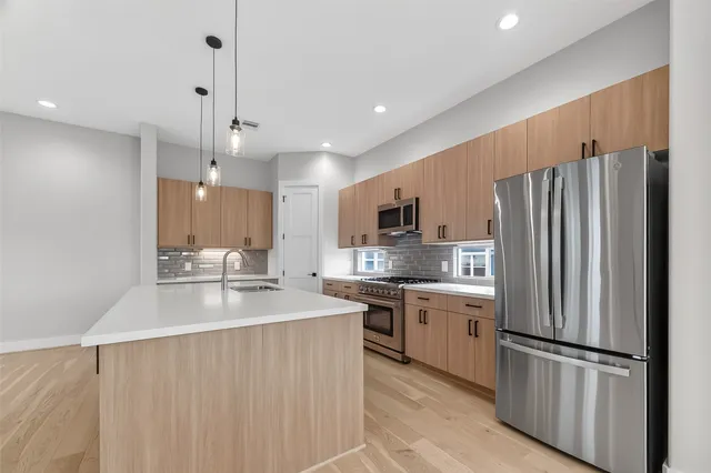 a kitchen with stainless steel appliances a sink stove and cabinets