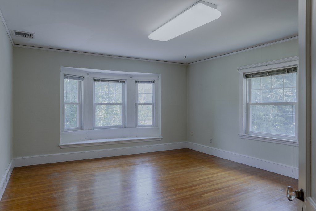 16 Audubon Road Lexington, MA 02421 - Photo 20 of 30 an empty room with wooden floor and windows