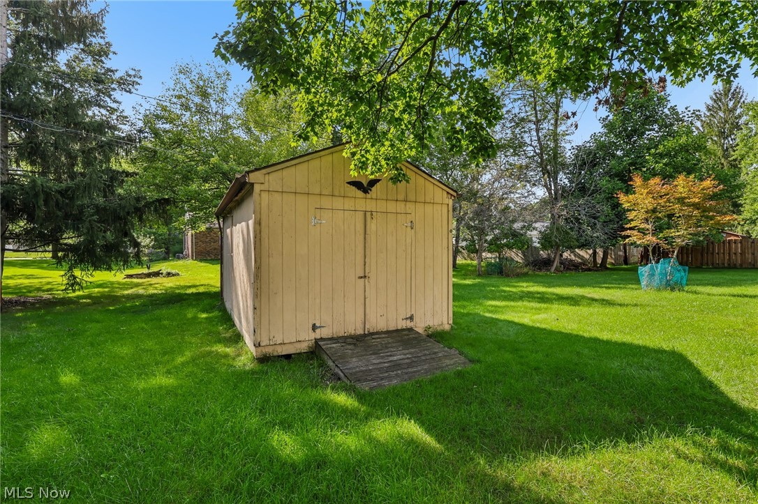 8310 Broadview Road Broadview Heights, OH 44147 - Photo 27 of 32 Detached storage shed with double doors, wood ramp access, set on a grassy expanse, surrounded by mature trees