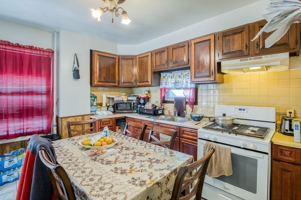 30 Adams Street Springfield, MA 01105 - Photo 17 of 23 a kitchen with a stove a sink a refrigerator cabinets and dining table
