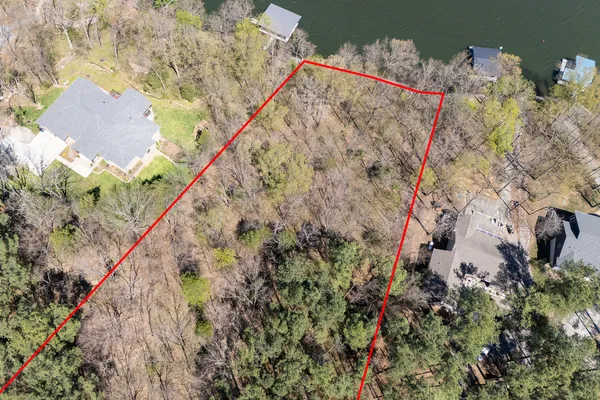 an aerial view of a house with a yard and lake view