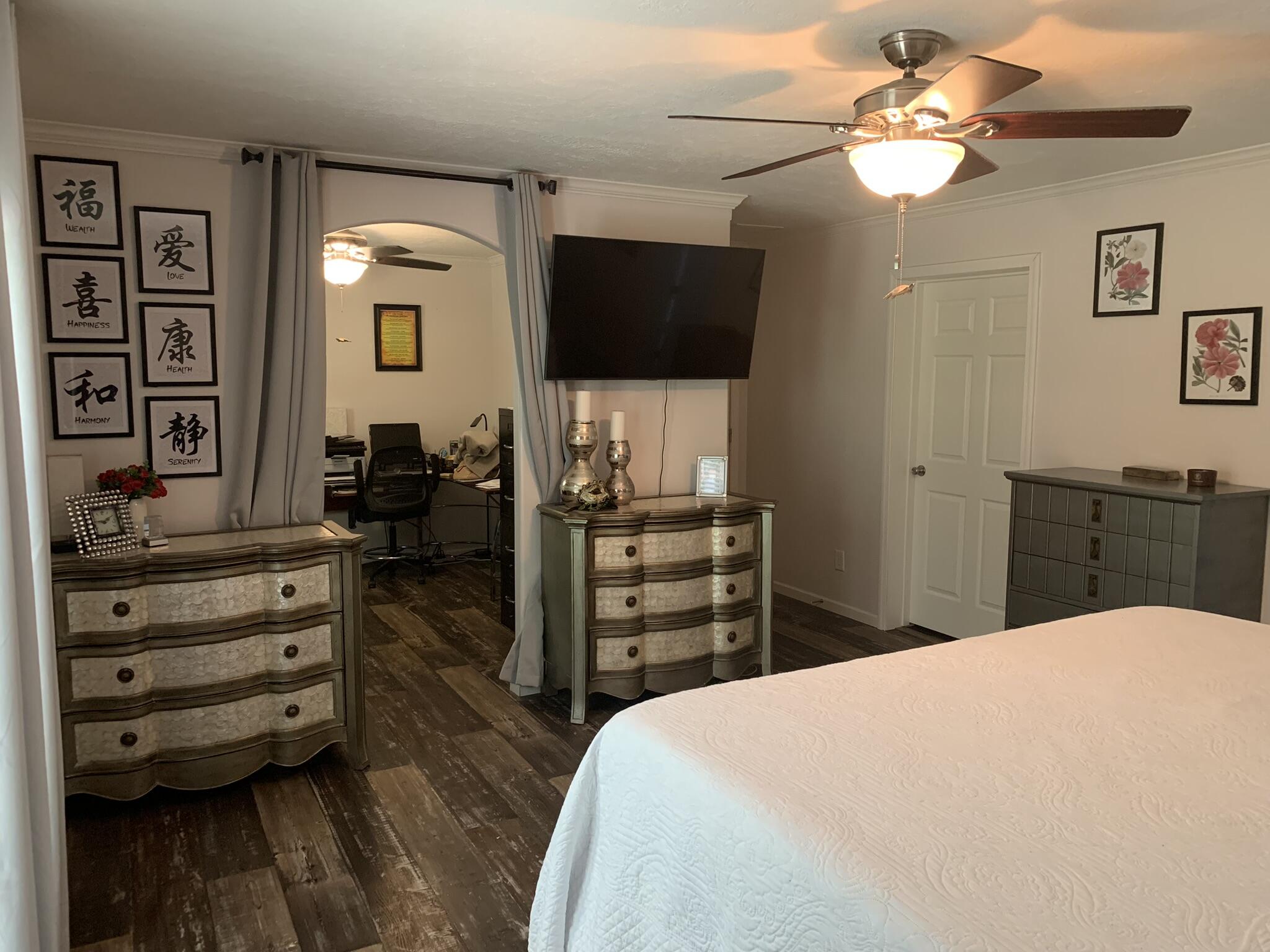 6196 Lake Ella Road Crestview, FL 32539 - Photo 18 of 29 a bedroom with a bed and a flat tv screen on dresser