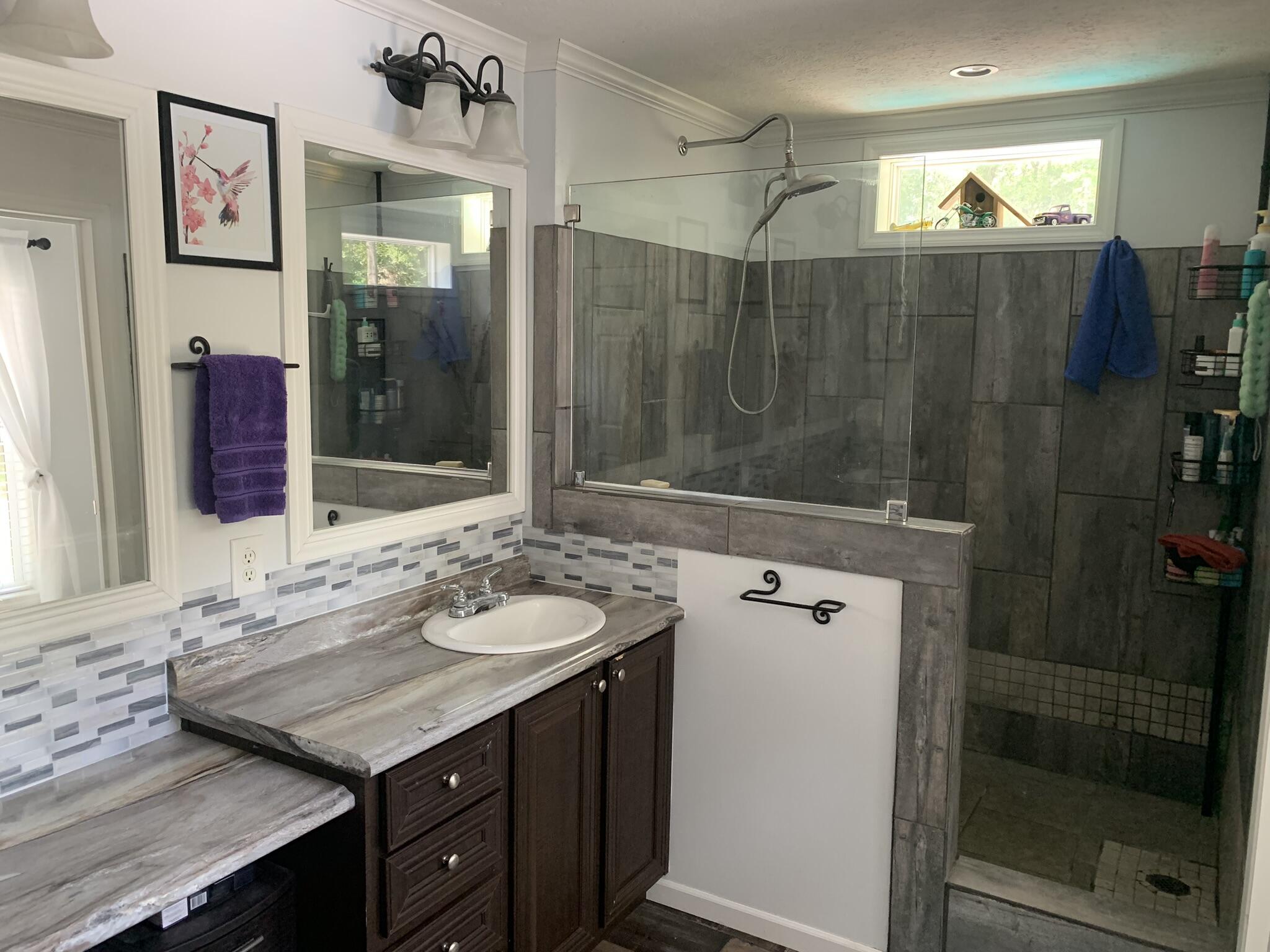 6196 Lake Ella Road Crestview, FL 32539 - Photo 19 of 29 a bathroom with a granite countertop sink mirror and shower
