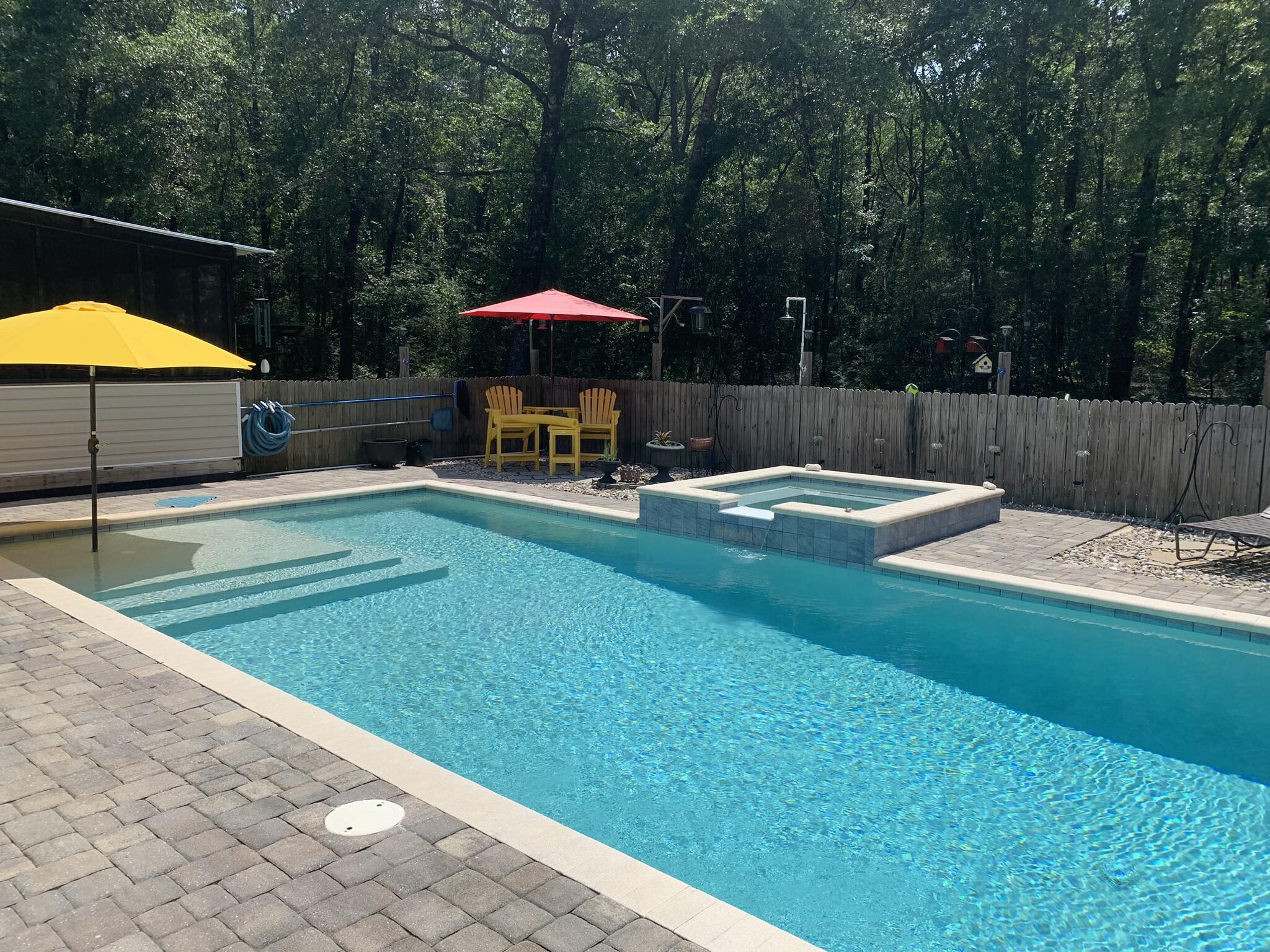6196 Lake Ella Road Crestview, FL 32539 - Photo 25 of 29 a view of pool with lawn chairs under an umbrella