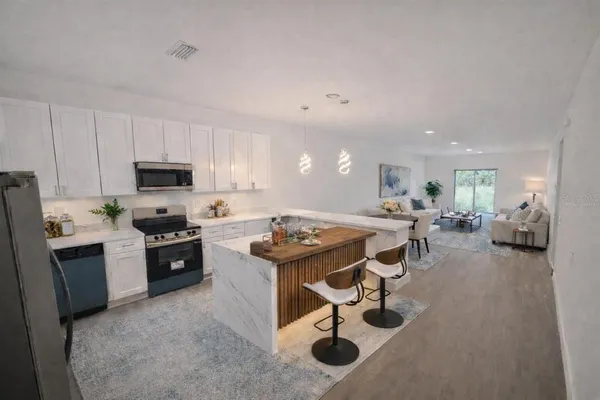 a kitchen with a sink a counter top space appliances and cabinets