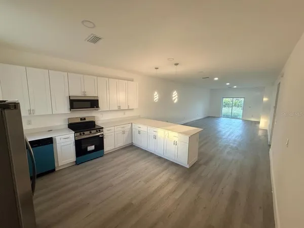 a large kitchen with stainless steel appliances granite countertop a large counter top and a stove top oven
