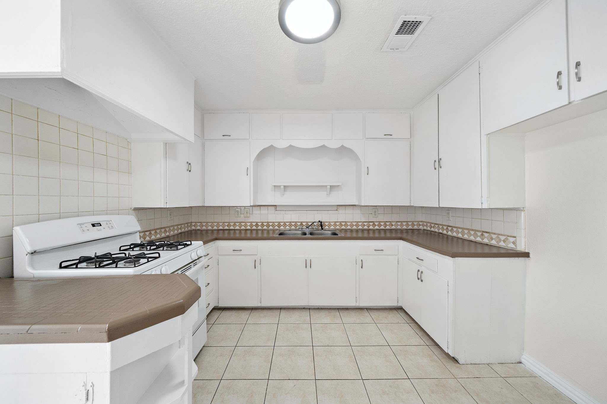 404 Milwaukee Street Houston, TX 77009 - Photo 4 of 19 a kitchen with granite countertop a sink a stove and cabinets