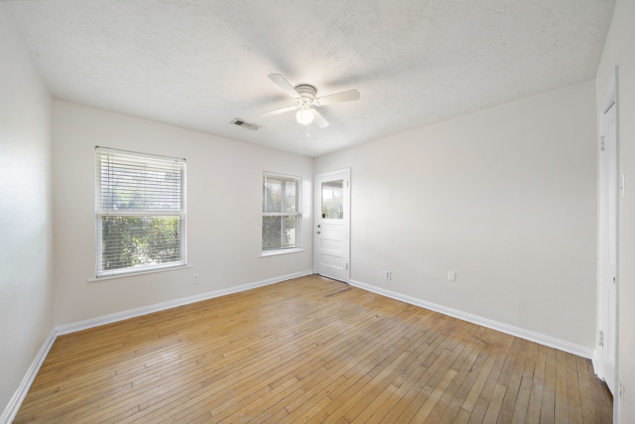 404 Milwaukee Street Houston, TX 77009 - Photo 5 of 19 a view of an empty room with a window and wooden floor