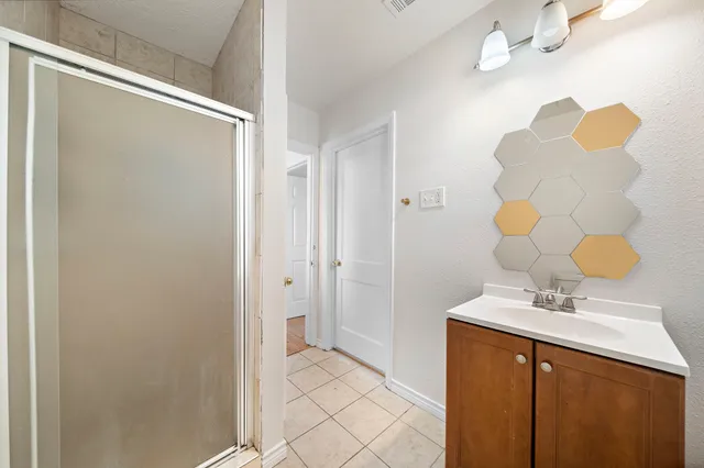 a bathroom with a sink mirror and a shower