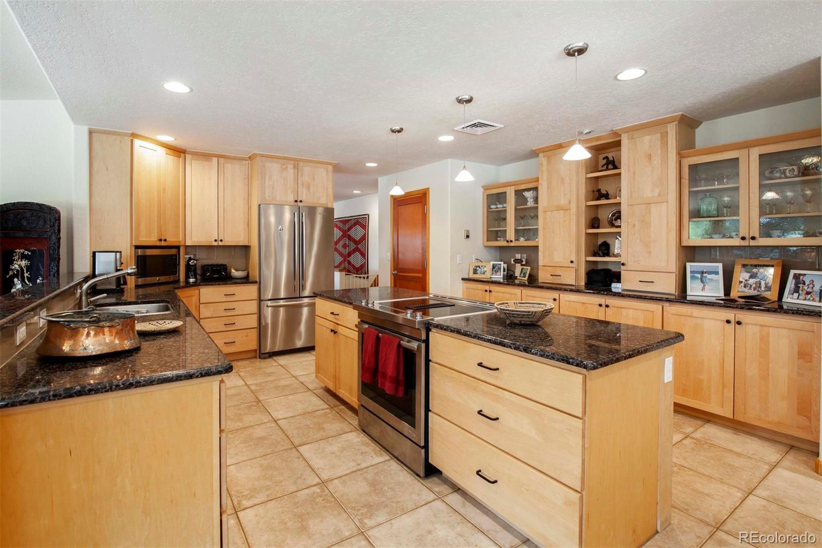 18332 Stone Gate Drive Morrison, CO 80465 - Photo 15 of 40 a kitchen with stainless steel appliances granite countertop a sink stove and cabinets