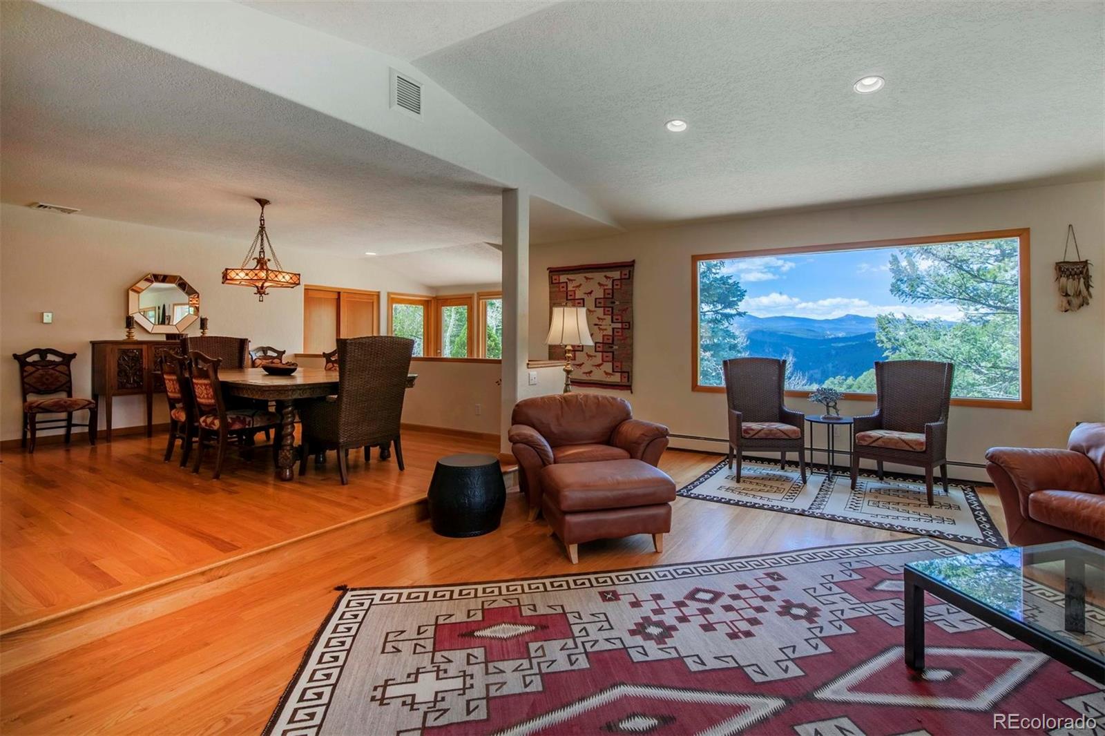 18332 Stone Gate Drive Morrison, CO 80465 - Photo 18 of 40 a living room with furniture a rug and a floor to ceiling window