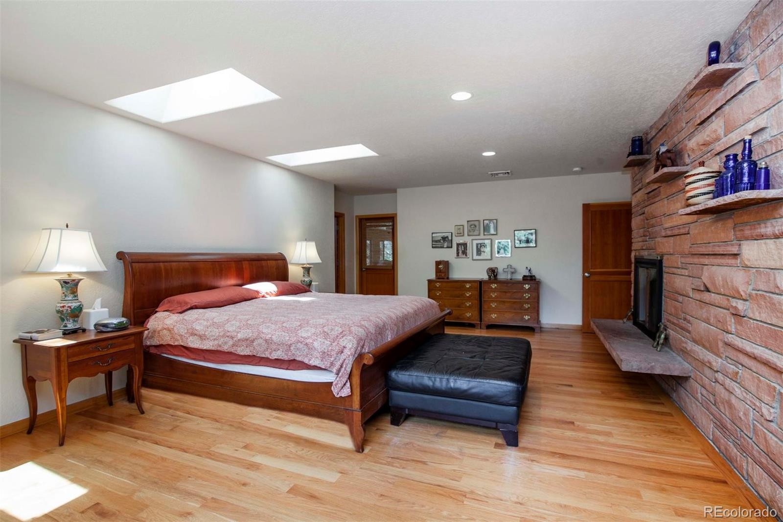 18332 Stone Gate Drive Morrison, CO 80465 - Photo 22 of 40 a bedroom with a bed and wooden floor