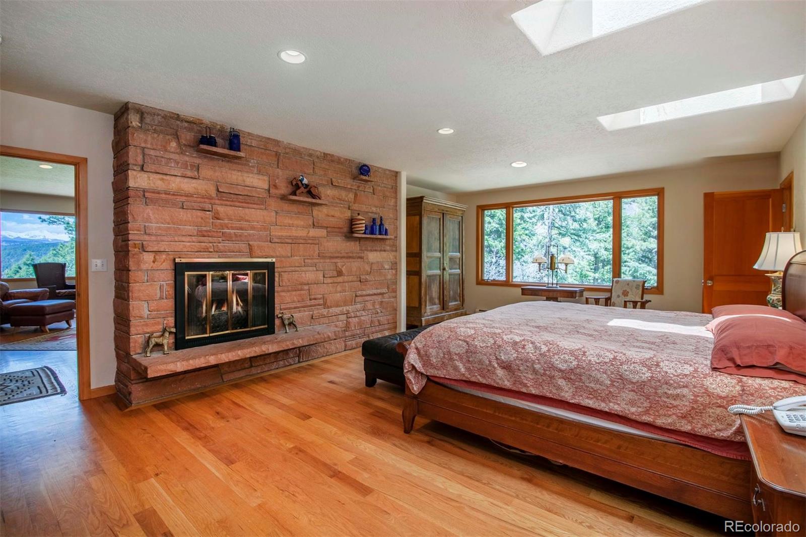 18332 Stone Gate Drive Morrison, CO 80465 - Photo 23 of 40 a bed room with a bed and a fireplace