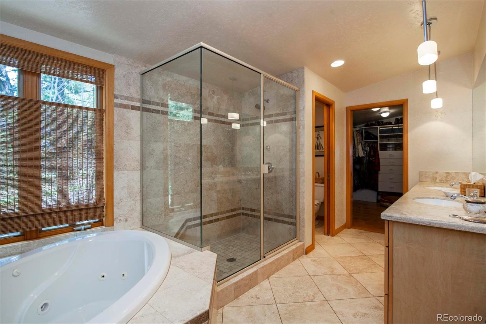 18332 Stone Gate Drive Morrison, CO 80465 - Photo 25 of 40 a bathroom with a bathtub and a shower