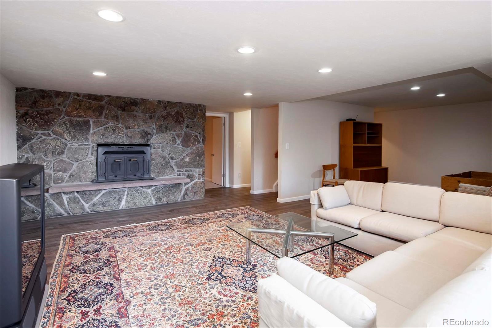 18332 Stone Gate Drive Morrison, CO 80465 - Photo 32 of 40 a living room with furniture and a fireplace