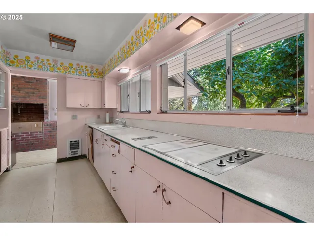 a kitchen with a stove a sink and a window