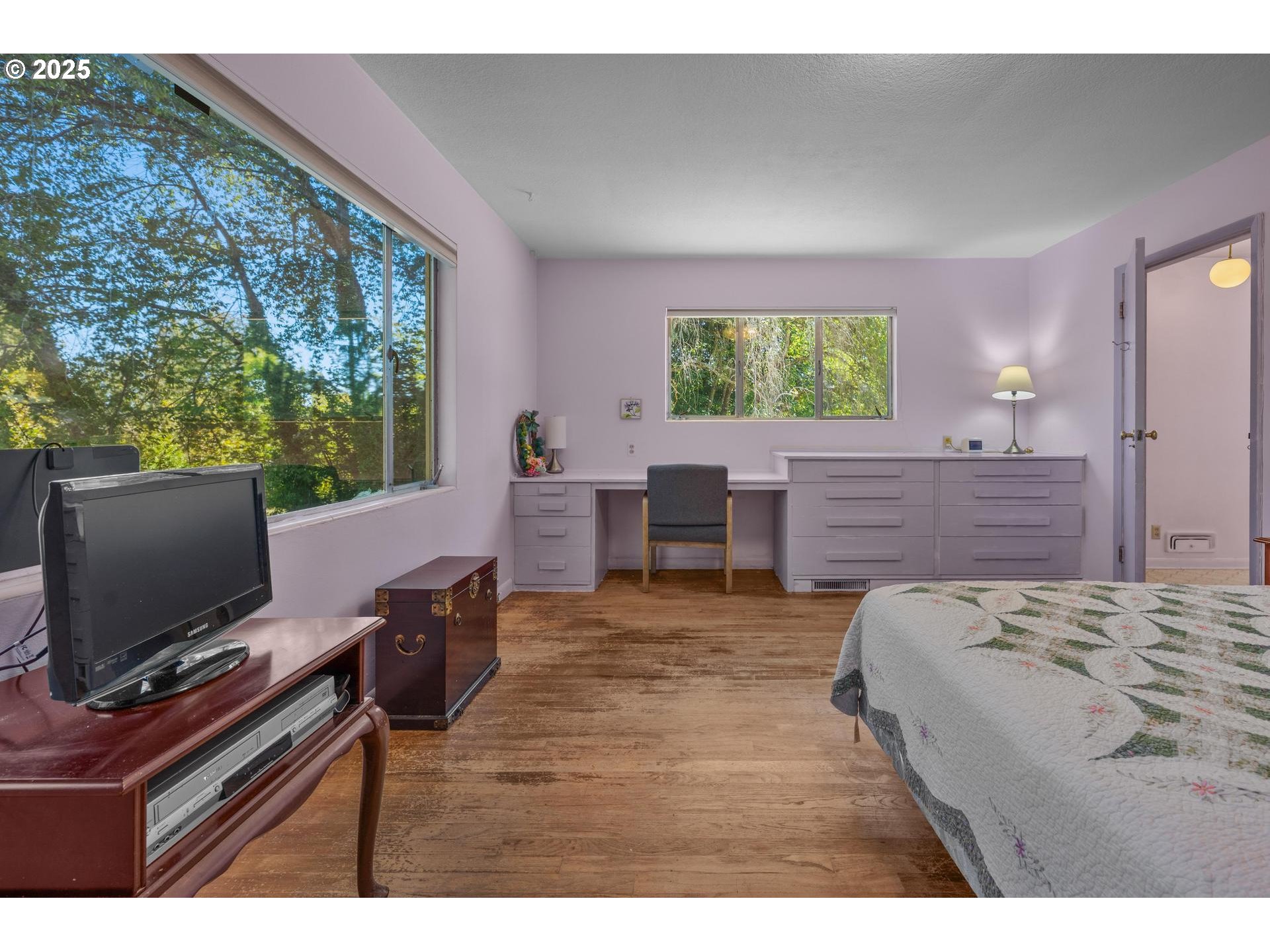 11990 Southwest Denney Road Beaverton, OR 97008 - Photo 15 of 40 a living room with a bed and a flat screen tv