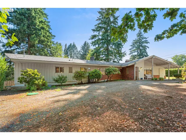 a front view of a house with a yard and potted plants