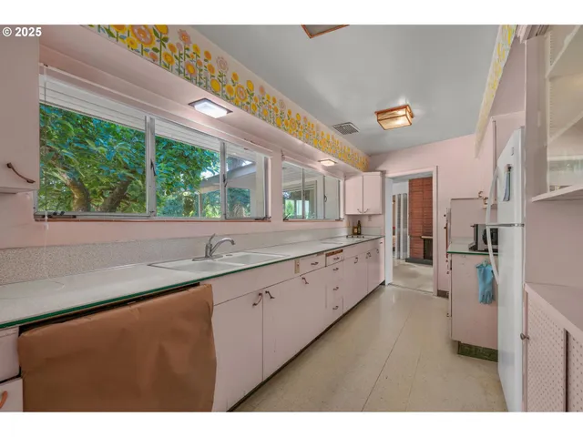 a large white kitchen with a large window