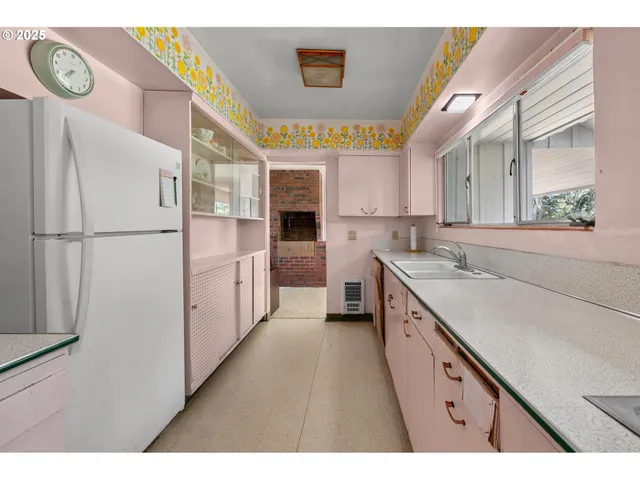 a kitchen with a refrigerator a stove top oven and a sink