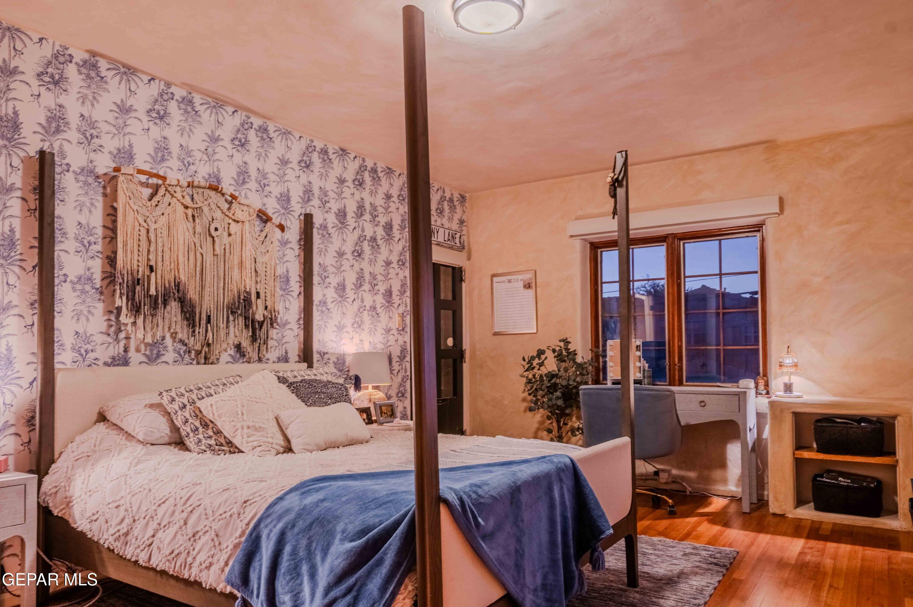 701 Rim Road El Paso, TX 79968 - Photo 30 of 54 a bedroom with a large bed and a chandelier