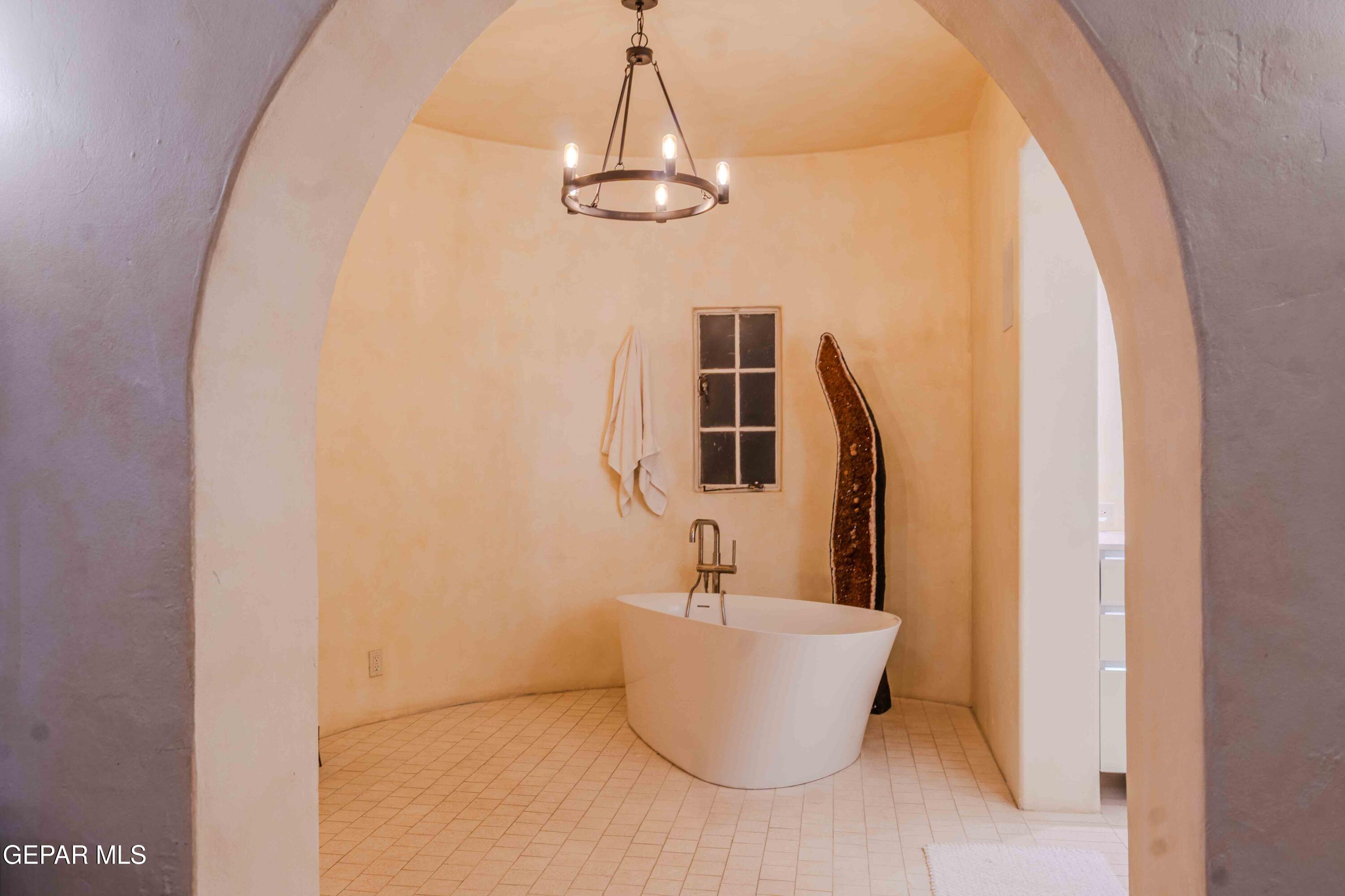 701 Rim Road El Paso, TX 79968 - Photo 37 of 54 a bathroom with a bathtub and chandelier