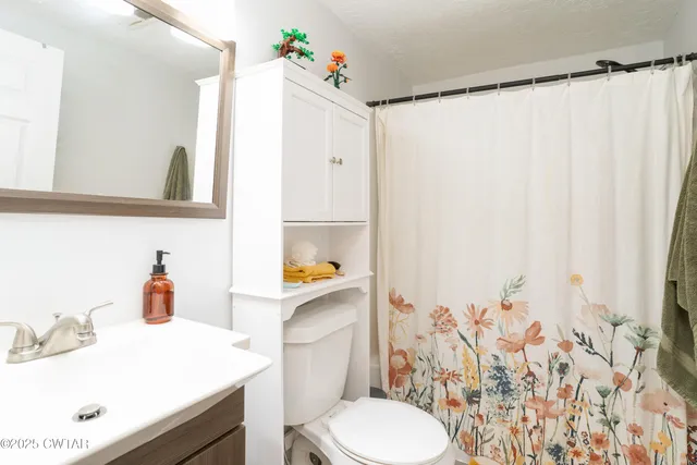 a bathroom with a sink vanity mirror and toilet
