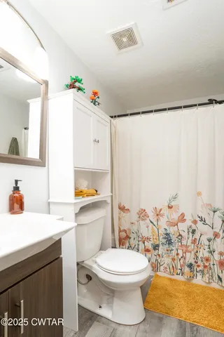a bathroom with a sink mirror vanity and toilet