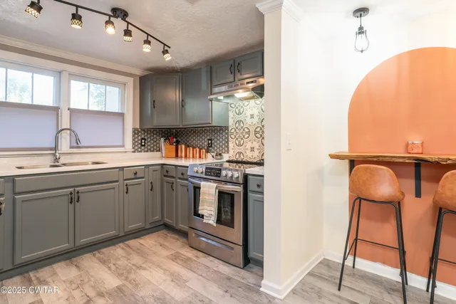 a kitchen with stainless steel appliances granite countertop a sink and cabinets