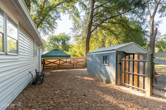 a view of a house with a yard and wooden fence