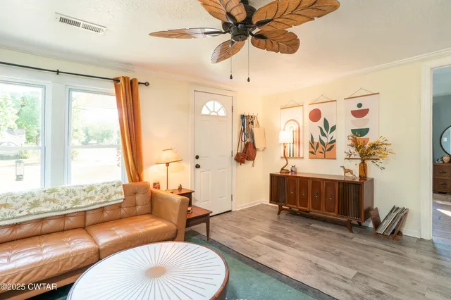 a living room with furniture and a wooden floor