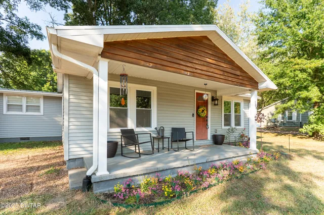 a view of a house with backyard and sitting area