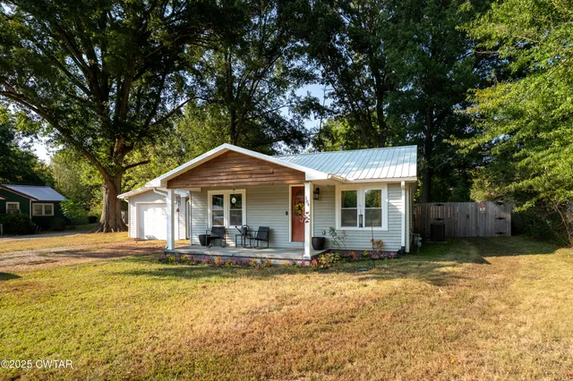 a front view of a house with a yard outdoor seating and garage