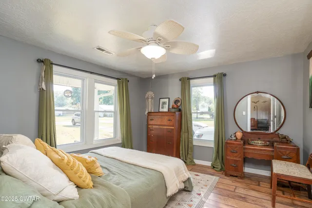 a bedroom with a bed a dresser next to a window