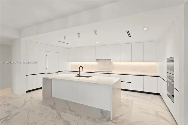 a kitchen with stainless steel appliances a refrigerator and white cabinets