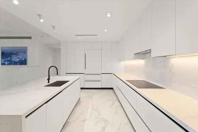 a kitchen with stainless steel appliances a refrigerator sink and white cabinets