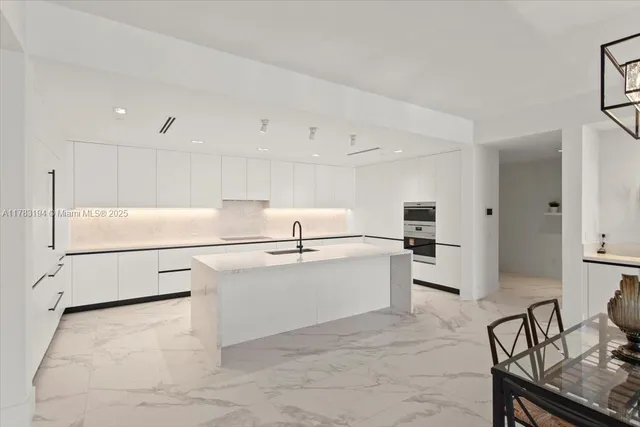 a kitchen with stainless steel appliances a refrigerator sink and white cabinets